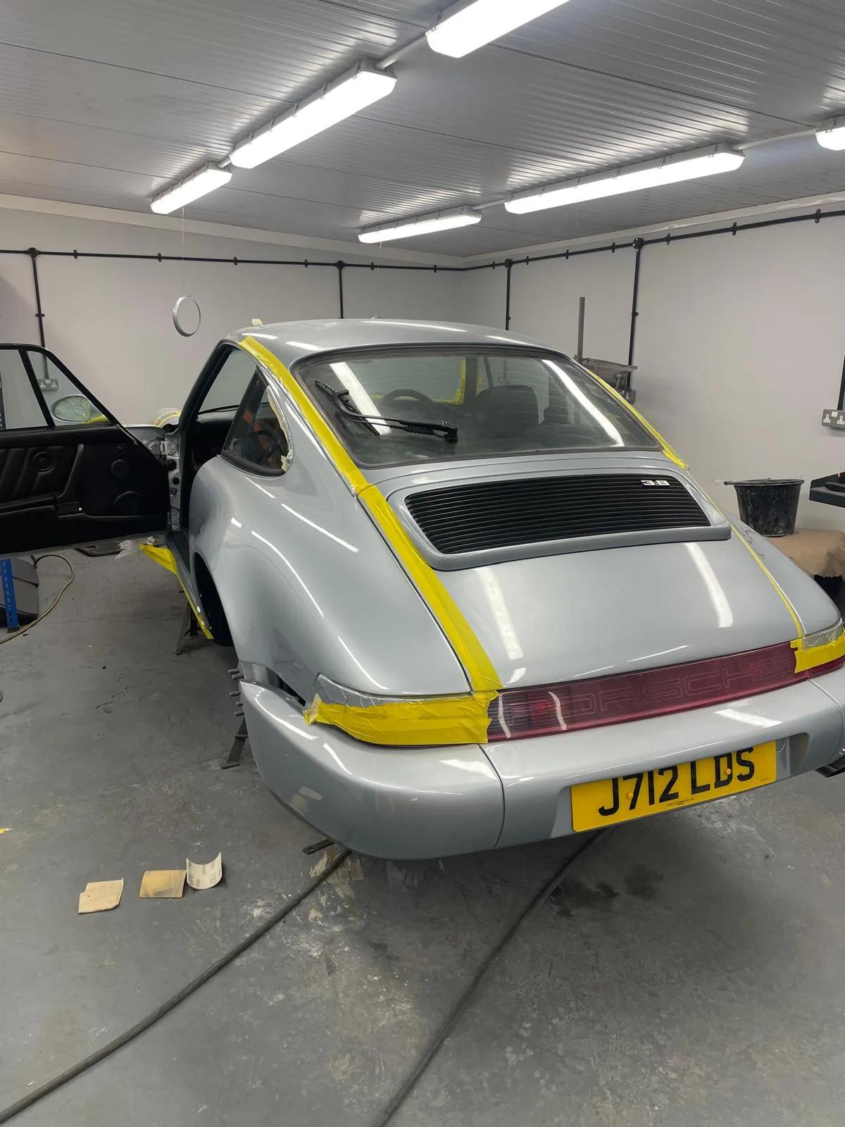 Porsche 911 race car with yellow striped livery